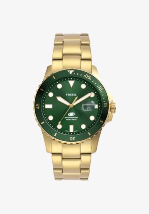 Montre-bracelet en métal doré avec cadran vert, index luminescents, lunette tournante, loupe de date et étanchéité jusqu'à 100 mètres.