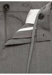 Pantalon gris avec fermeture éclair partiellement ouverte, fermeture par bouton et doublure intérieure blanche visible.