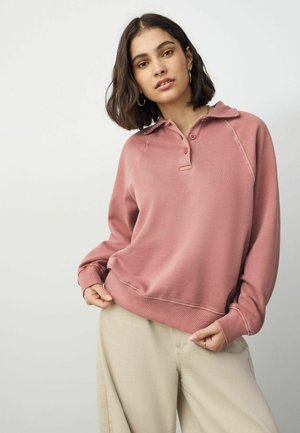 Lichtroze pullover sweatshirt met een kraag, knopenlijst en geribde mouwen. Glad materiaal met een ontspannen pasvorm, gecombineerd met beige broek.