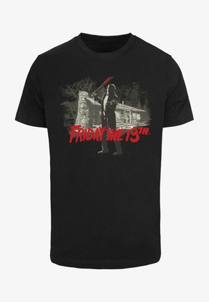 Fekete pamut póló, amelyen egy fegyvert tartó alak grafikája látható egy kunyhó előtt, piros "FRIDAY THE 13th" felirattal.
