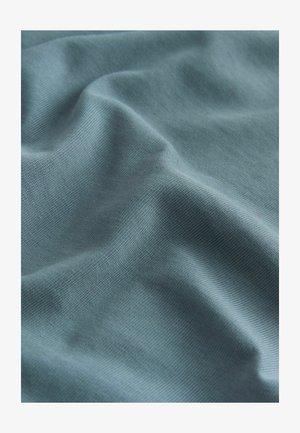 Šviesiai mėlyna medžiaga su glotnia tekstūra, rodanti švelnų drapavimą ir smulkų audimo raštą. Be ryškių akcentų ar detalės.