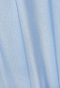 Světle modrý zmačkaný materiál s hladkým povrchem, který má jemný lesk a nepravidelné záhyby. Oblast ukazuje záhyby a drapérii.