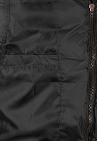 Schwarze gepolsterte Jacke mit glatter, glänzender Textur, seitlichem Reißverschluss und einer Brusttasche mit einem schlichten Klappen-Design.