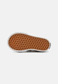 Podeszwa buta z gumowym dnem, z wzorem plastra miodu, białymi ścianami bocznymi i teksturowaną powierzchnią w jasnobrązowym kolorze.