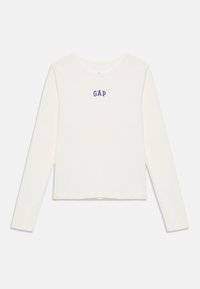 T-shirt blanc à manches longues et col rond avec le logo "GAP" en bleu centré sur la poitrine, affiché à plat sur un fond blanc.