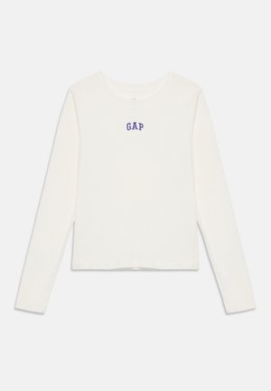 T-shirt blanc à manches longues et col rond avec le logo "GAP" en bleu centré sur la poitrine, affiché à plat sur un fond blanc.