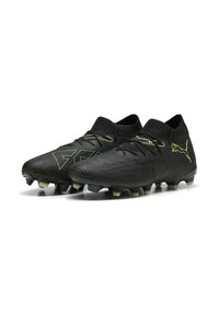 Botas de fútbol negras con acentos verdes, parte superior texturizada y diseño de cuello alto. Los tacos en punta proporcionan tracción en superficies de hierba.