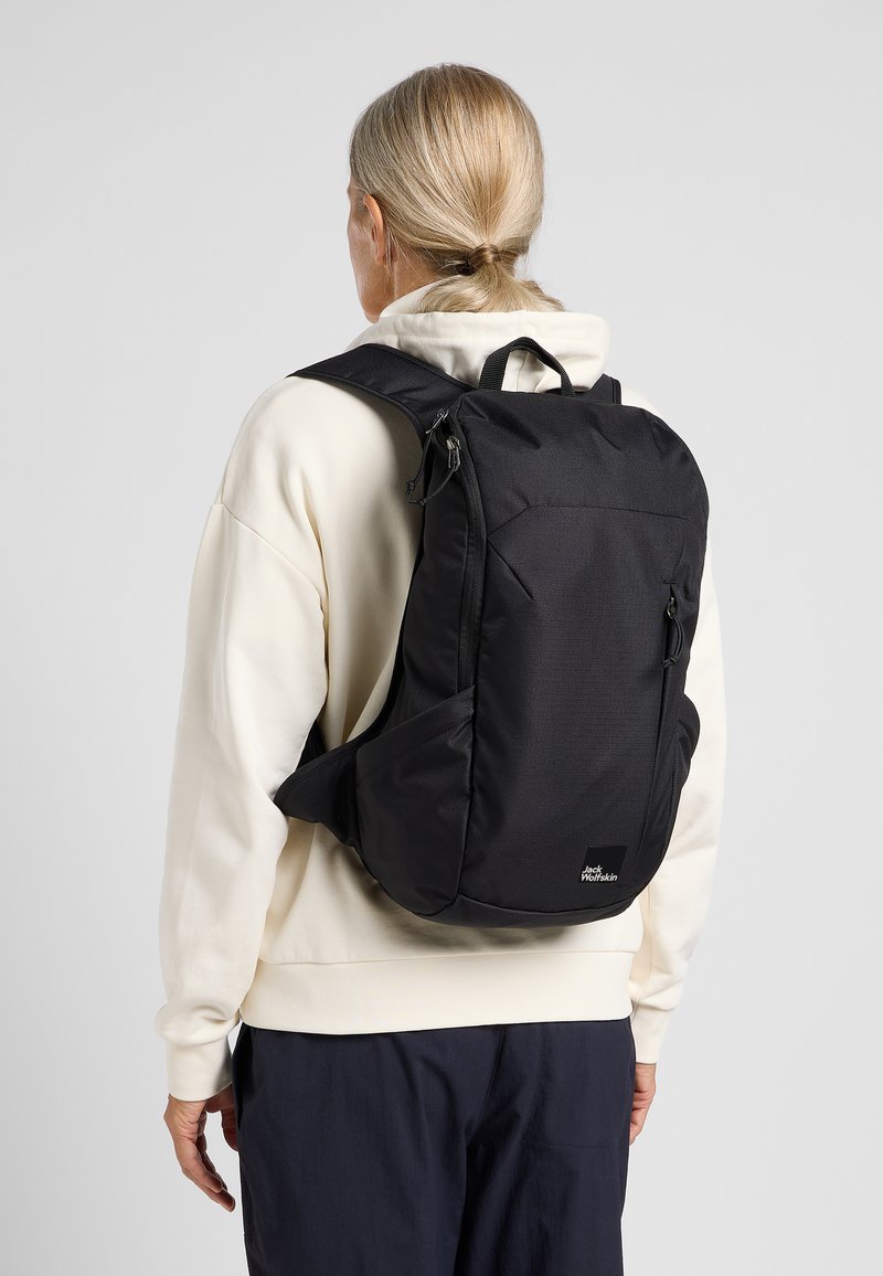 Black fabric backpack with a sleek design, featuring adjustable straps, a front zip pocket, and brand logo at the bottom front.