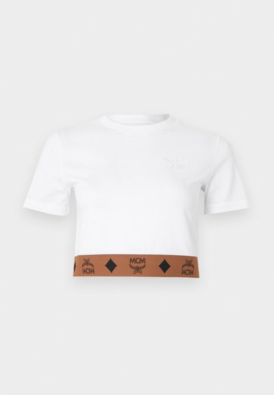 Λευκό κοντομάνικο crop t-shirt από βαμβάκι, με καφέ λωρίδα που φέρει εκτυπωμένο λογότυπο στο κάτω μέρος με διαμαντένια σχέδια και κεντημένη λεπτομέρεια λογότυπου.