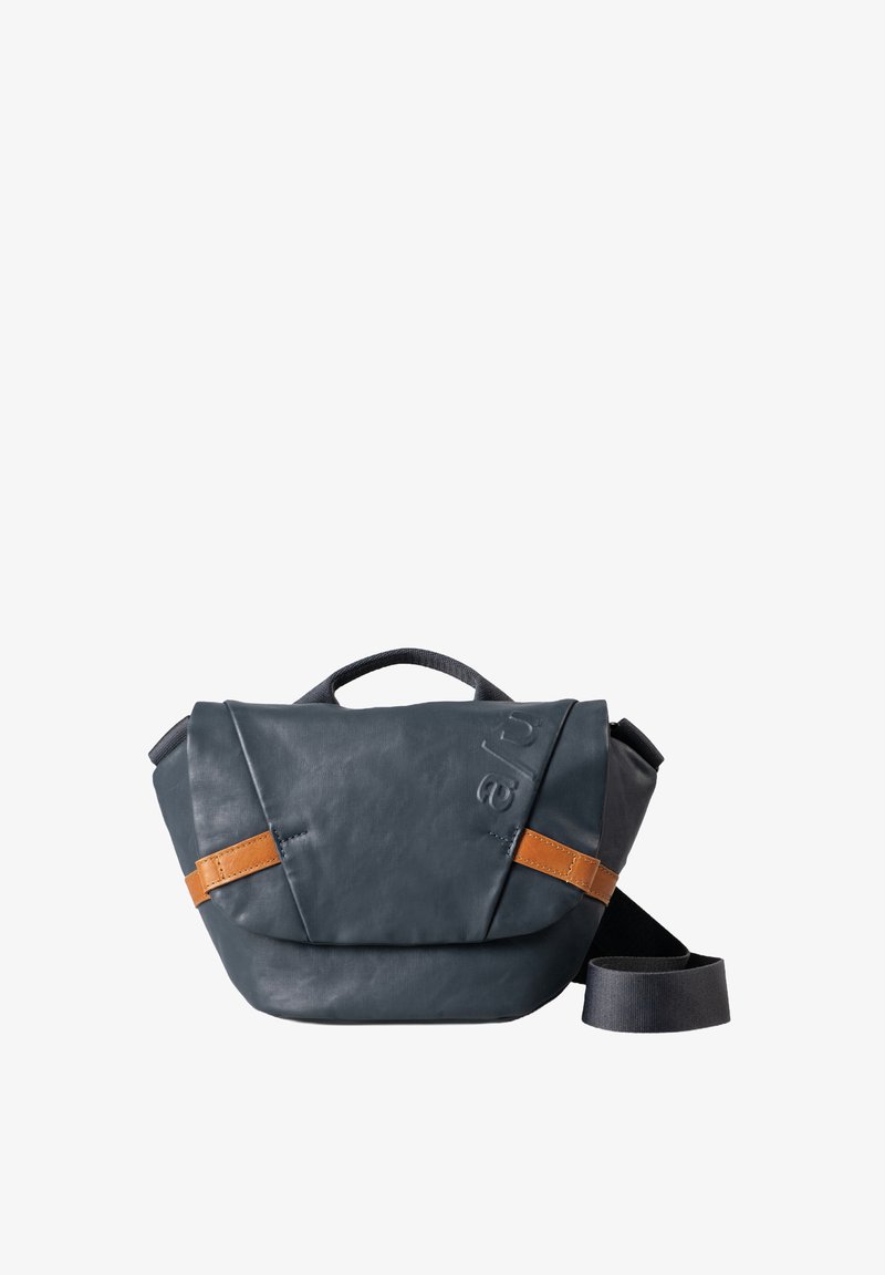 Borsa in pelle blu scuro con una forma strutturata, dotata di una tracolla in pelle marrone e di una tracolla regolabile in tessuto nero.