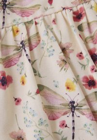 Blumige Stoffe mit rosa Libellen und mehrfarbigen Blumen auf einem hellen Hintergrund. Weiche Textur mit plissierten Details.