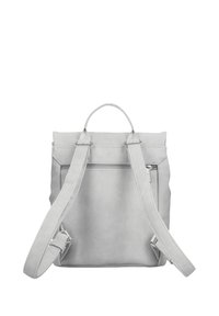 Mochila de cuero gris claro con correas ajustables, asa en la parte superior y bolsillo externo con cremallera en el panel trasero.