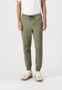 Olijfgroene joggers met een elastische tailleband en trekkoord. Tapered pijpen met elastische boorden, gemaakt van lichtgewicht stof.