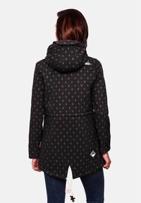 Black jacket with a hood, featuring a dotted pattern, cinched waist, and side vents. Includes a drawstring and logo detail on the back.