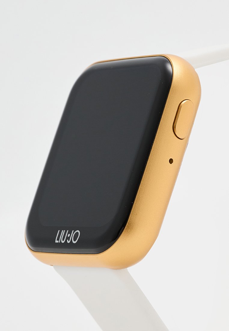 Orologio smartwatch con schermo rettangolare nero, cassa dorata, pulsante laterale e cinturino bianco, vista angolata su uno sfondo chiaro.