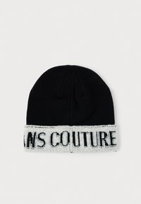 Crni pleteni beanie kapu s bijelim rebrastim rubom, s teksturiranim logom "COUTURE". Dizajn je jednostavan i prianja s okruglim vrhom.