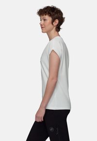 Biała koszulka z krótkim rękawem i podwiniętymi mankietami, miękka w dotyku, okrągły dekolt i płaski krój, zestawiona z czarnymi spodniami z logotypem.