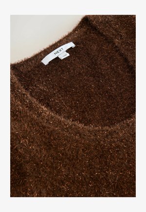 Brun fluffig tröja med en mjuk, texturerad yta. Har en bred halsringning och en etikett sydd vid kragen. Lågplynterad tyg med glans.