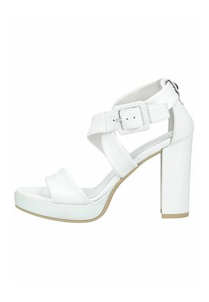 Witte sandaal met hoge hak, brede gekruiste banden, een grote gesp op het enkelbandje en een stevige blokhak.