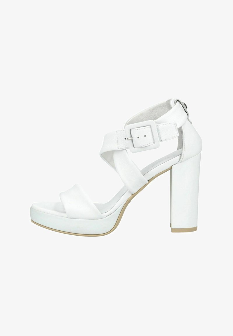 Sandale blanche à talon haut avec de larges brides croisées, une grande boucle sur la bride de la cheville et un talon épais.