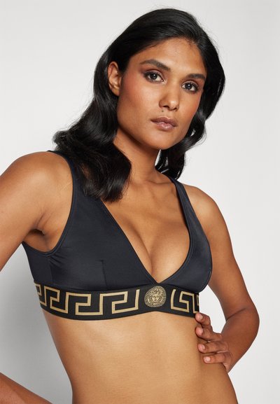 Must mustrind bralette, mis smooth kangast valmistatud. Omab kuldset Kreeka võtme mustrit ja embleemi paelal. Lihtne disain, ilma sisetugedeta.