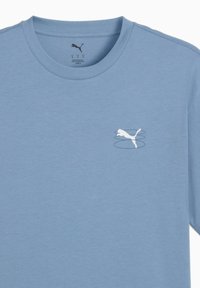 Tricou din bumbac de culoare albastru deschis, cu gât rotund, având un mic logo alb Puma și un design cu linii în zona stângă a pieptului.