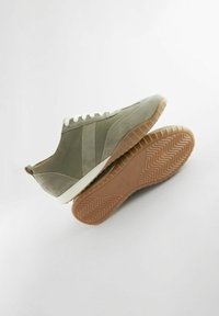 Grüne Wildleder-Sneaker mit einem glatten Obermaterial, weißen Schnürsenkeln, einer Gummisohle mit Fischgrätmuster und einem niedrigen Design.