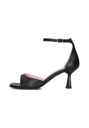 Black leather heeled sandal with an open toe, ankle strap, and a thin mid-height heel, featuring a curved design and a pink insole.