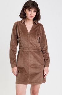 Robe en velours côtelé marron avec fermeture éclair �à l'avant, col, manches longues, et taille cintrée avec une légère évasement en bas. Détail de tissu texturé.