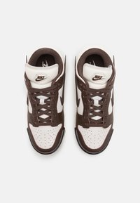 Nike högvänliga sneakers i brunt och krämfärgat läder. Funktioner inkluderar snörningsdesign, perforerat tåskåp och logotyp på tungan.