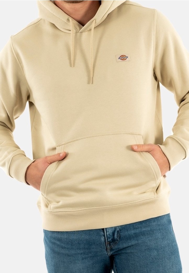 Felpa con cappuccio beige realizzata in un tessuto morbido, dotata di tasca frontale a marsupio e polsini a costine. Piccola toppa con logo sul petto.