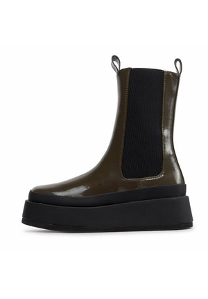 Wysokie botki Chelsea w ciemnooliwkowym kolorze z błyszczącym wykończeniem, czarnymi elastycznymi panelami po bokach oraz grubą czarną podeszwą.