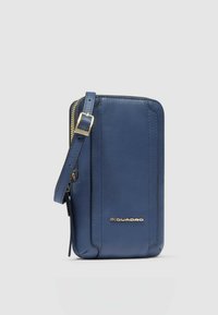 Portafoglio per telefono in pelle blu navy con chiusura a zip, tracolla staccabile e accessori color oro. Texture liscia con dettagli di cuciture sottili.