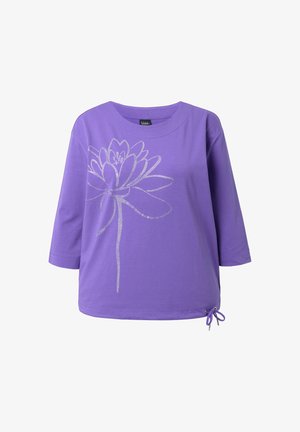 Fioletowa koszula z długim rękawem z dużym kwiatowym wzorem obrysowanym srebrem na przodzie oraz małą zawiązaną kokardką na dolnym prawym brzegu.