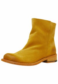 Botín de ante amarillo hasta el tobillo con punta redonda, tacón de corcho bajo y detalles de costura mínimos en la parte superior.