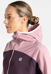 Lila und rosa Reißverschlussjacke mit hohem Kragen, kontrastierenden Stoffabschnitten und einem Logo auf der Brust. Glatte Textur, athletic fit.