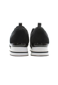 Sneaker nere con tomaia in suede e rete. Presentano una spessa suola bianca con strisce nere e un'etichetta sul retro per facilitarne l'indossamento.