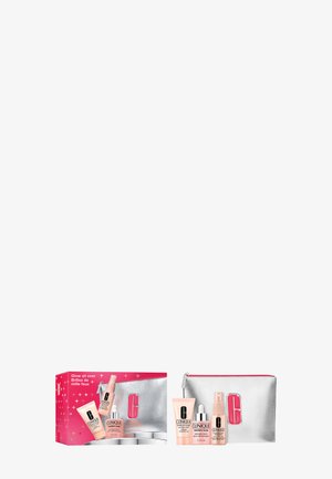 Clinique gift set in a pink box with silver accents; includes four skincare products in tubes and a shiny silver pouch with pink zipper.
