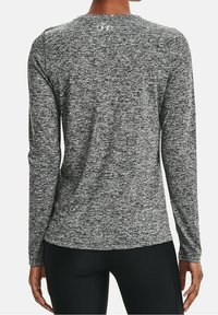 Langarm-Sportshirt aus schwarz-weißer melierter Stoffqualität, mit rundem Ausschnitt und Logodetail auf dem oberen Rücken.