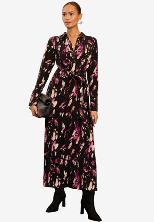 Langärmliges Kleid aus schwarzem Stoff mit einem bunten Blumenmuster. Verfügt über einen Kragen, einen Taillengürtel und eine fließende Silhouette.