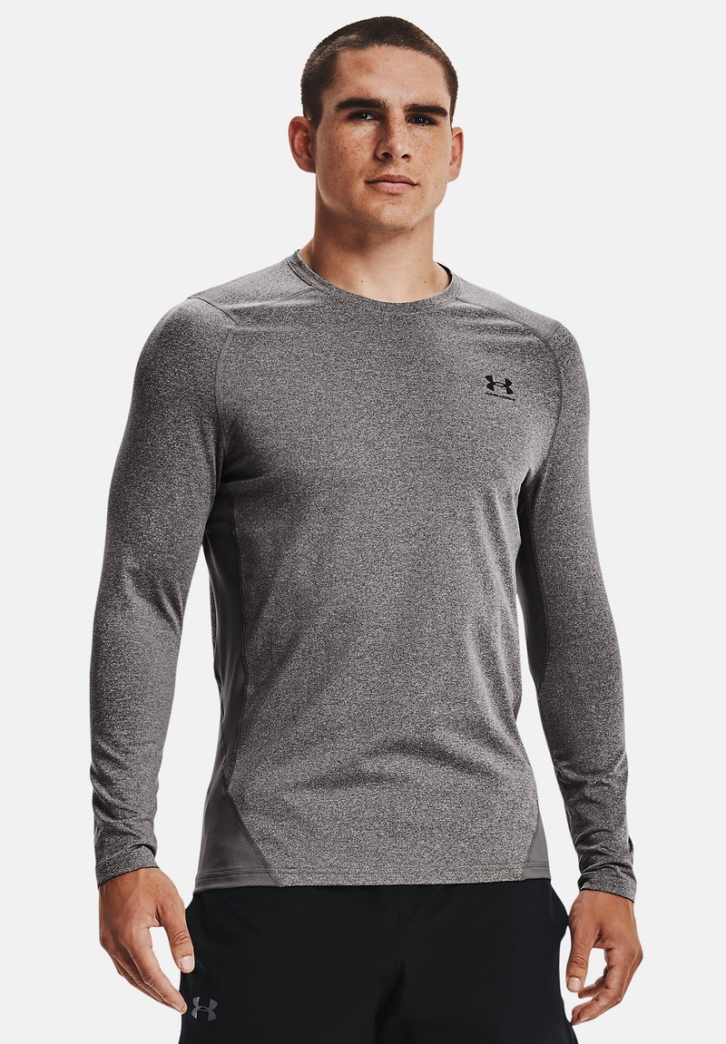 Grå langermet treningsskjorte laget av et teksturert materiale, med rund hals og en liten svart logo på brystet.