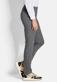 Grijze op maat gemaakte broek met een slim fit, een gladde textuur en een klassieke tailleband, gecombineerd met sportieve sneakers in beige en zwart.
