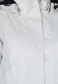 Witte jas met een zachte, gladde textuur, voorzien van een hoge kraag, zichtbare stiksels en verstelbare hardware bij de nek.