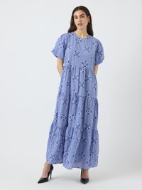 Blå rutmönstrad maxiklänning med puffärmar, blommiga detaljer, lager på lager-skirt och rund halsringning. Bärs tillsammans med svarta högklackade skor.
