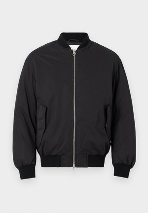 Chaqueta bomber negra hecha de tela suave, con cierre de cremallera en el frente, puños acanalados, bolsillos laterales y un diseño clásico de cuello redondo.