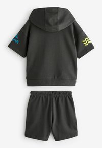 Ciemnoszara krótkosleeve'owa bluza z kapturem z niebieskimi i żółtymi akcentami, w zestawie z dopasowanymi szortami. Wykonana z miękkiego, elastycznego materiału.