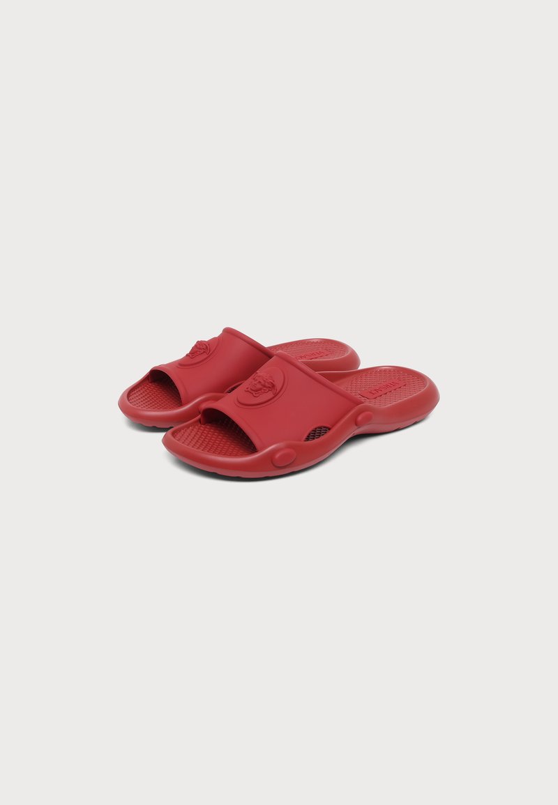Paar rote Slidesandalen mit strukturiertem Fußbett und geprägtem Logo auf dem breiten Riemen, vor einfachem hellem Hintergrund.