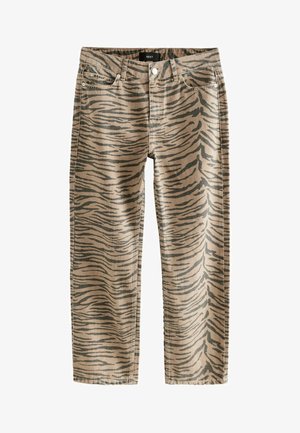 Beżowe dżinsy z charakterystycznym ciemnobrązowym wzorem w paski tygrysa. Zaprojektowane w prostym kroju, z pięcioma kieszeniami i zapięciem na guzik z przodu.