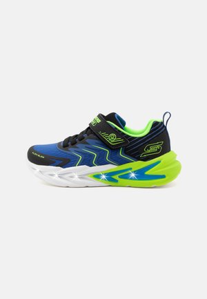 Child's blue, black, and neon green sneaker with velcro strap and light-up sole glowing along the white and green midsole.