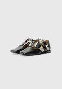 Black leather shoes with a pointed toe design, featuring a wide strap with decorative silver buckles and an accent at the side.